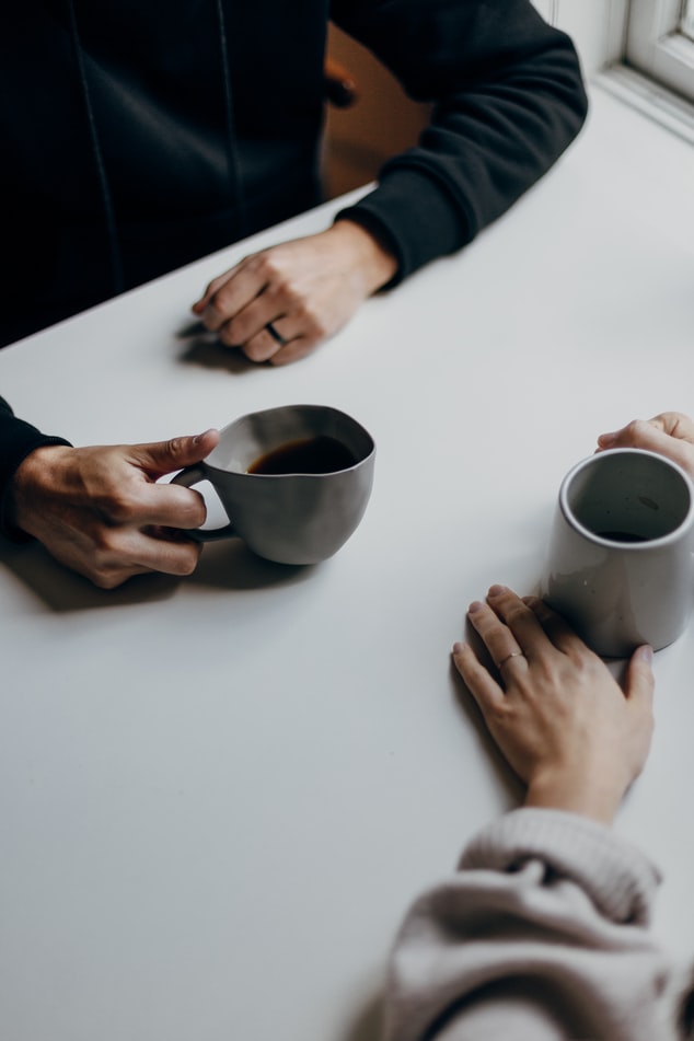 Two Peoples' Hands Holding Coffee Mugs (full size)